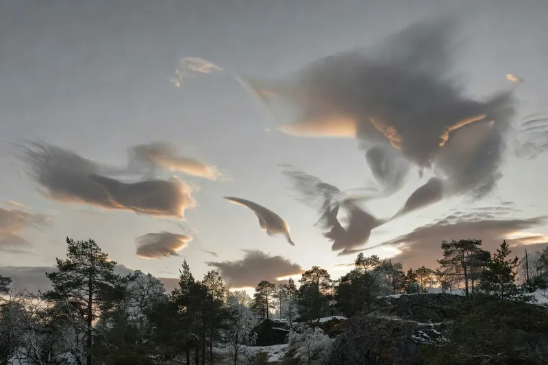 Lumière rasante sur des nuages dont les formes suggèrent des silhouettes changeantes.